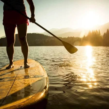Paddleboarding on calm water at sunset